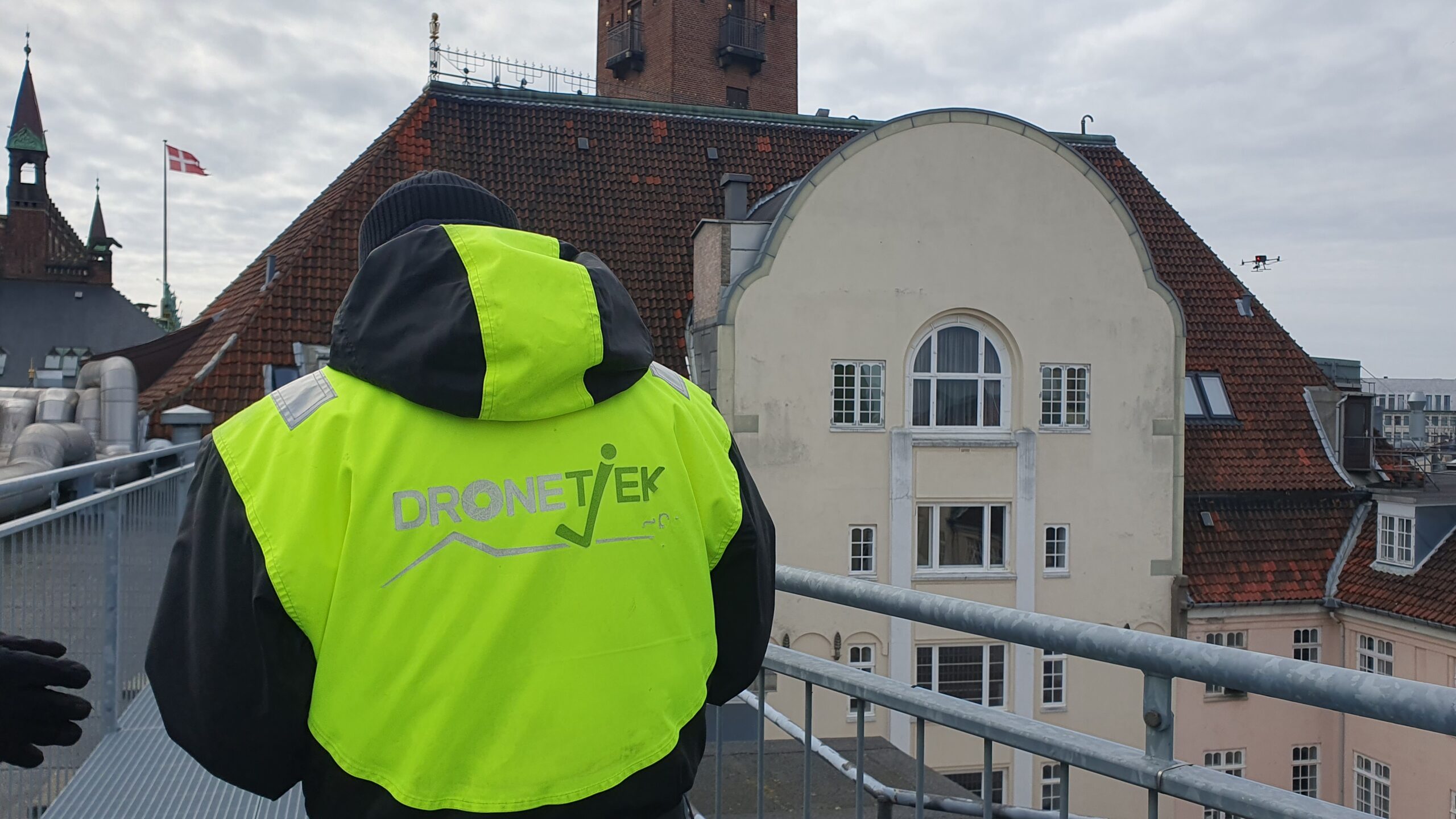DroneTjek pilot in high-vis jacket performing a drone inspection on site