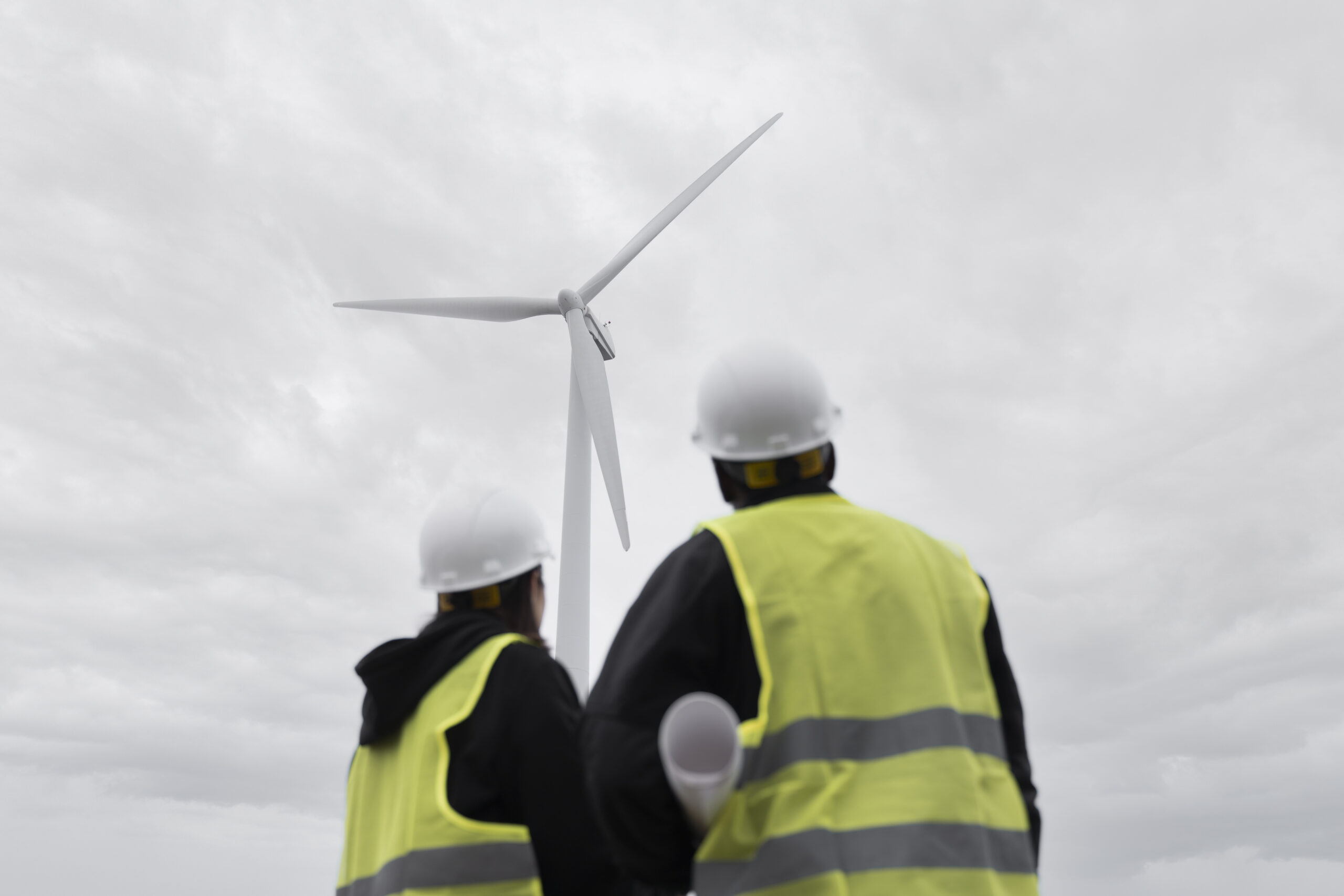Drone-based inspection crew working in the field near a wind turbine